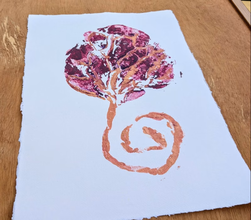 Voorbeeld plum placenta afdruk op katoenpapier. Kunstwerk van een placenta en navelstreng. Diepe heldere kleuren op een vel van zware kwaliteit met een rafel rand.